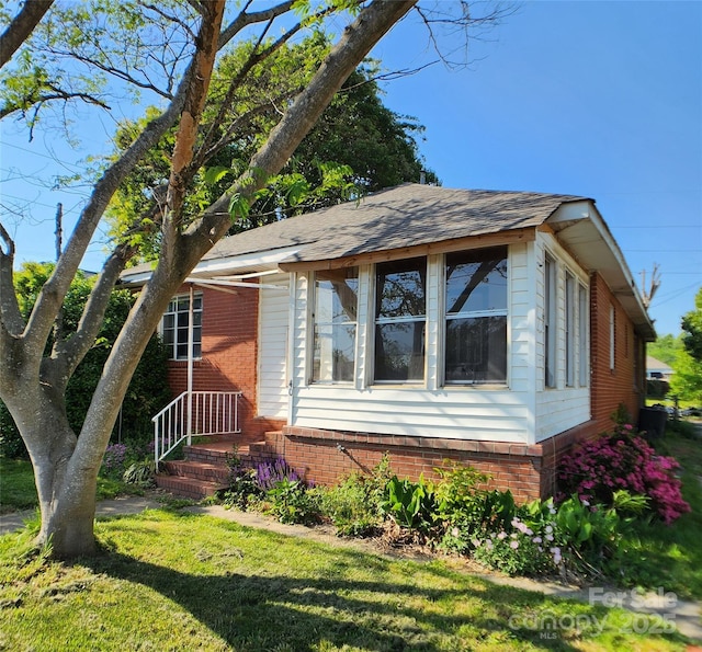 view of front of property featuring brick siding and a front lawn