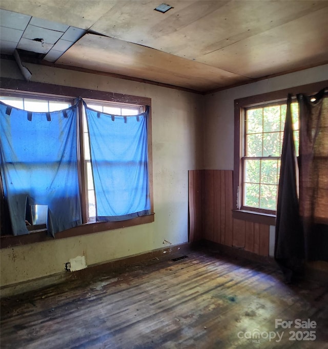 empty room featuring wood finished floors and visible vents