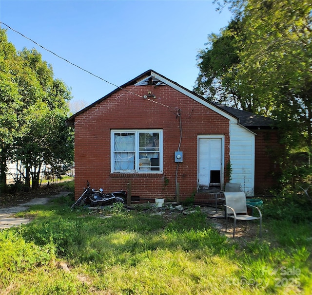 back of property featuring brick siding