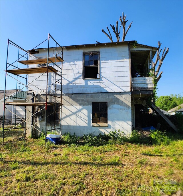 rear view of property featuring concrete block siding