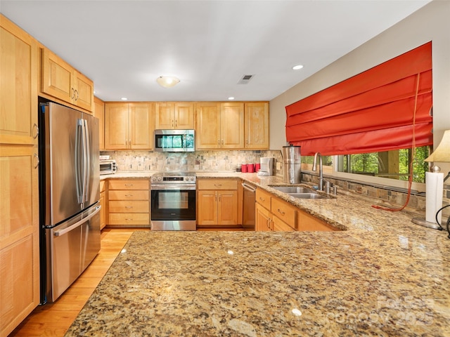 19 Old Patton Hill Rd, Swannanoa, NC 28778 - kitchen with stainless steel appliances, a sink, light wood-style flooring, light stone countertops, and decorative backsplash
