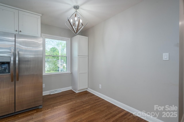 692 S Pink St, Cherryville, NC 28021 - unfurnished dining area with visible vents, a notable chandelier, baseboards, and dark wood-type flooring