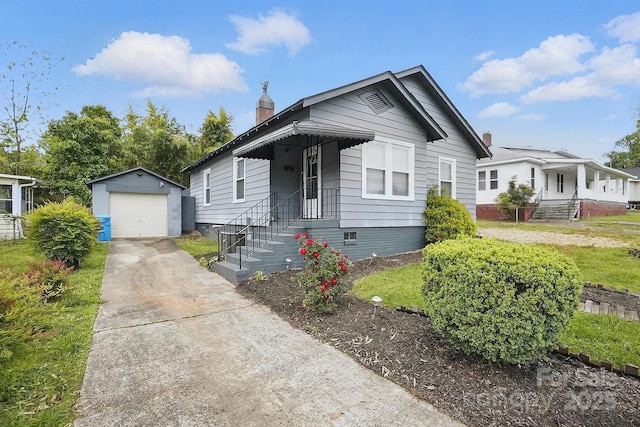 view of front of home featuring a chimney, driveway, an outbuilding, and a detached garage