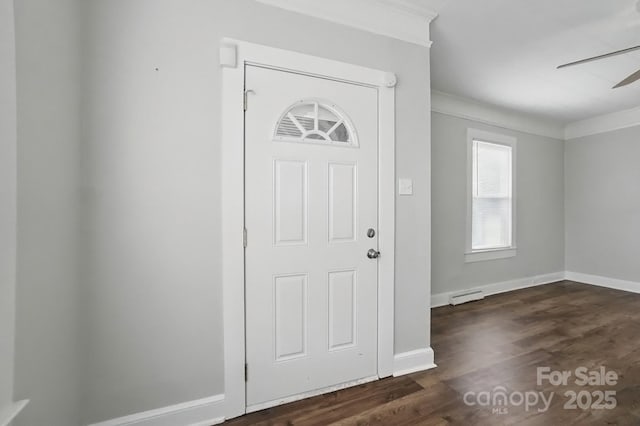 entrance foyer featuring dark wood finished floors, baseboards, ornamental molding, ceiling fan, and a baseboard radiator