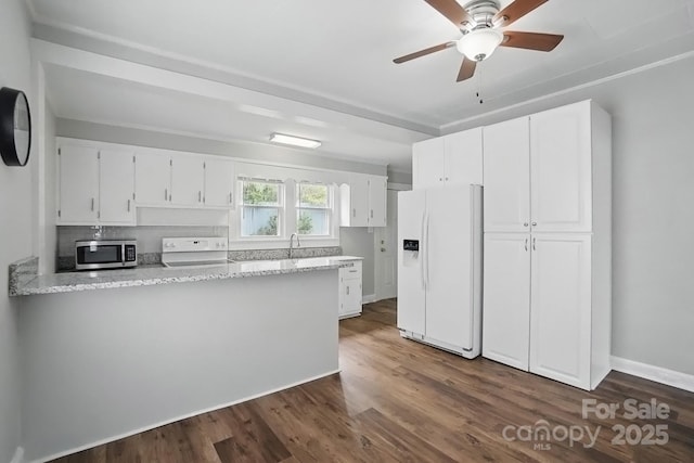 kitchen featuring stainless steel microwave, electric range oven, white cabinetry, and white refrigerator with ice dispenser