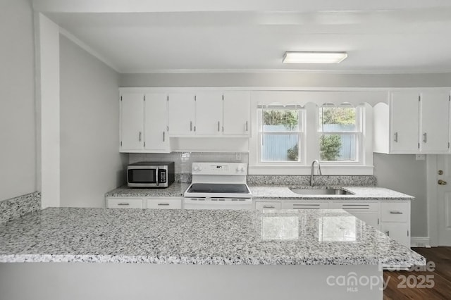 kitchen featuring electric stove, a sink, white cabinets, stainless steel microwave, and light stone countertops