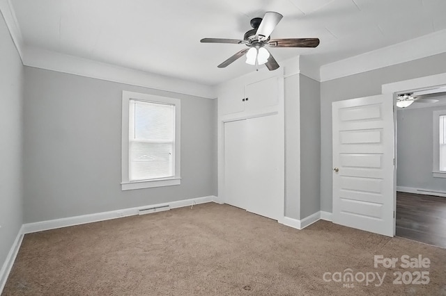 unfurnished bedroom with baseboards, visible vents, multiple windows, and carpet