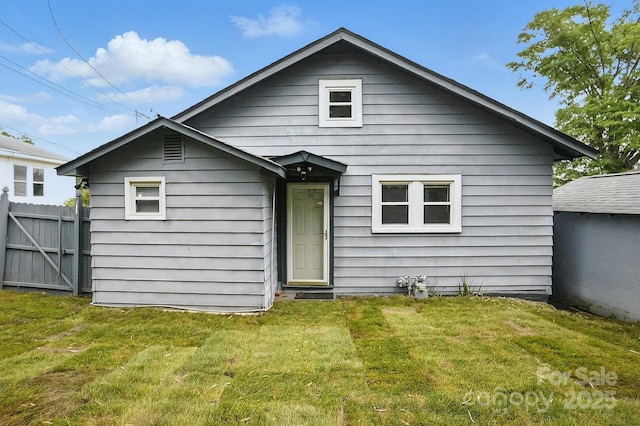 back of house with fence and a yard
