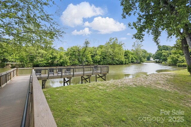 view of dock featuring a yard and a water view
