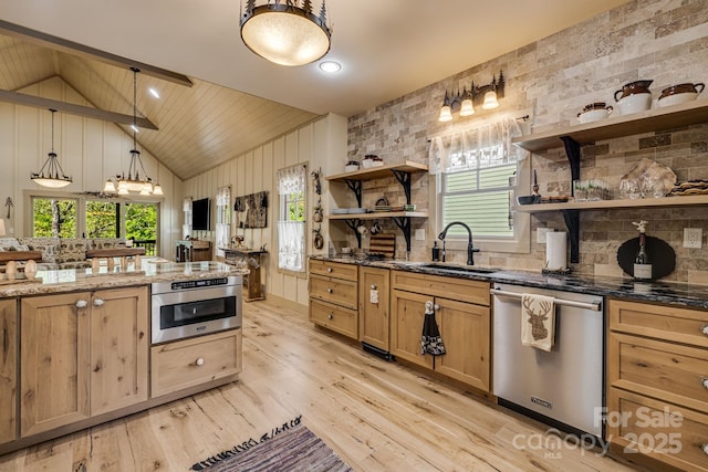 kitchen featuring plenty of natural light, appliances with stainless steel finishes, open shelves, light wood-type flooring, and a sink