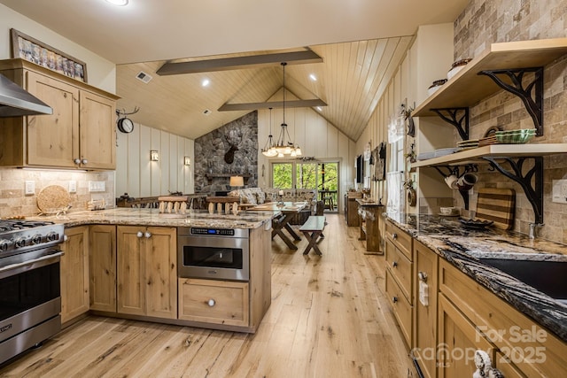 kitchen with open shelves, a peninsula, light wood-style floors, light stone counters, and appliances with stainless steel finishes