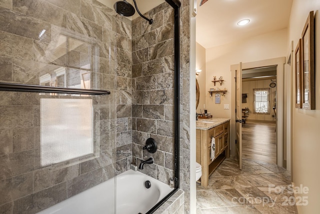 bathroom with tiled shower / bath combo, toilet, and vanity