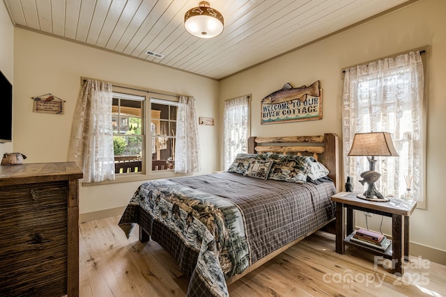 bedroom featuring crown molding, baseboards, wooden ceiling, and wood finished floors