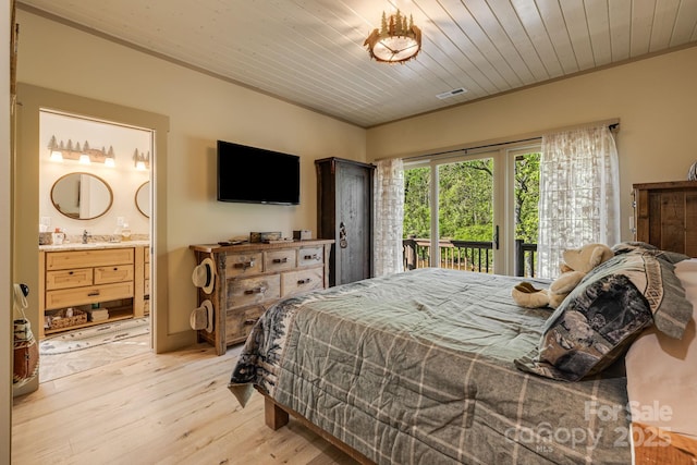 bedroom with ensuite bathroom, visible vents, light wood-type flooring, a sink, and access to outside