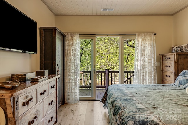 bedroom featuring light wood-type flooring, ornamental molding, visible vents, and access to exterior