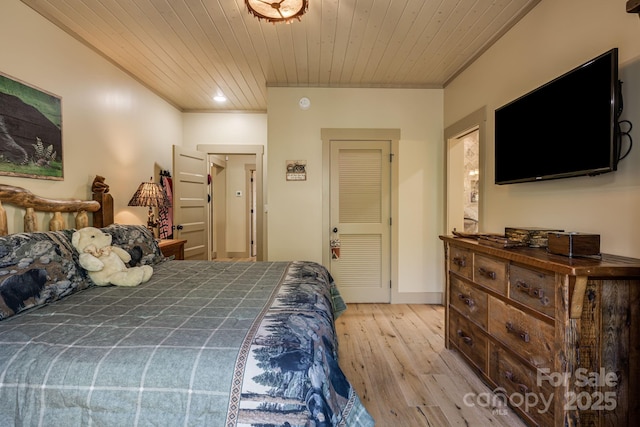 bedroom with crown molding, wood ceiling, and light wood finished floors