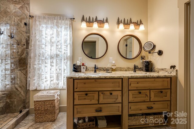bathroom featuring a sink, double vanity, and tiled shower