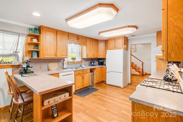 kitchen with open shelves, a sink, white appliances, light countertops, and a peninsula