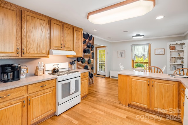 kitchen with crown molding, light wood-style floors, light countertops, white gas stove, and under cabinet range hood