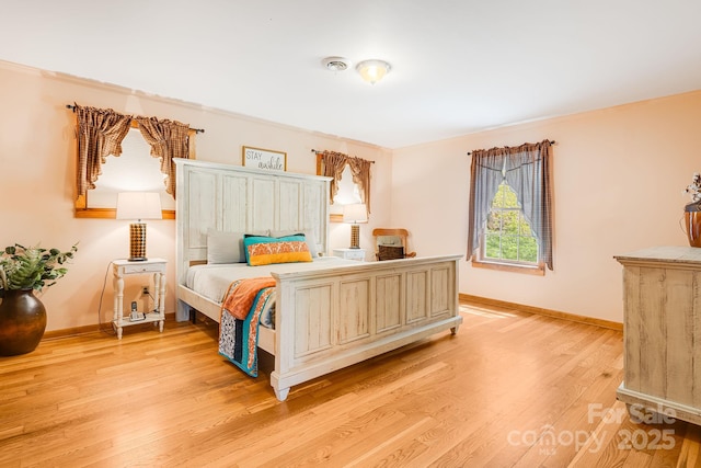 bedroom featuring baseboards and light wood-style flooring