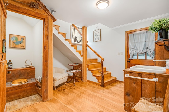 interior space with crown molding, baseboards, and wood finished floors