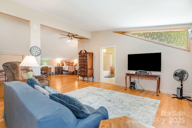 living area featuring ceiling fan, vaulted ceiling, and wood finished floors