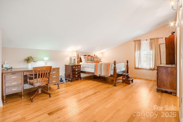 bedroom with baseboards, vaulted ceiling, and wood finished floors
