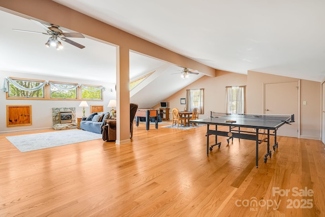 playroom featuring baseboards, ceiling fan, vaulted ceiling, and light wood-style flooring