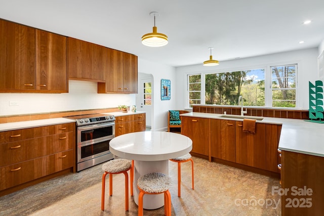 80 Sunset Dr, Marshall, NC 28753 - kitchen featuring brown cabinets, a sink, double oven range, decorative light fixtures, and light countertops