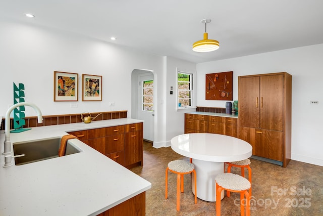 80 Sunset Dr, Marshall, NC 28753 - kitchen with brown cabinetry, light countertops, a sink, and arched walkways