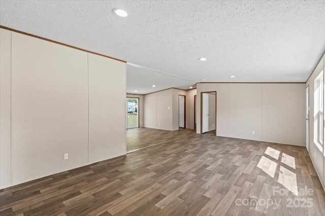 unfurnished living room with a textured ceiling, wood finished floors, and recessed lighting