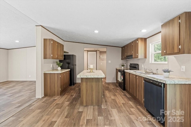 kitchen with light wood-style floors, black appliances, light countertops, a sink, and brown cabinets