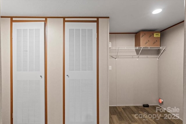 laundry area with a heating unit and wood finished floors
