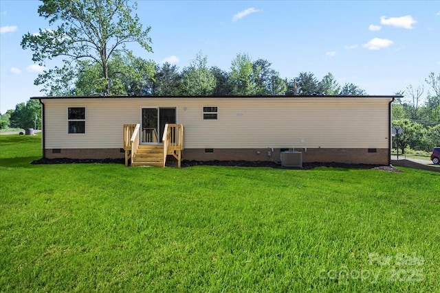back of house featuring a yard, cooling unit, and crawl space