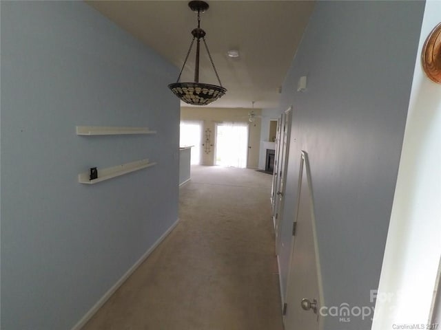 hallway with carpet flooring and baseboards