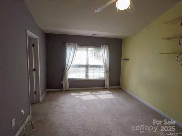 empty room featuring carpet floors, a ceiling fan, and baseboards