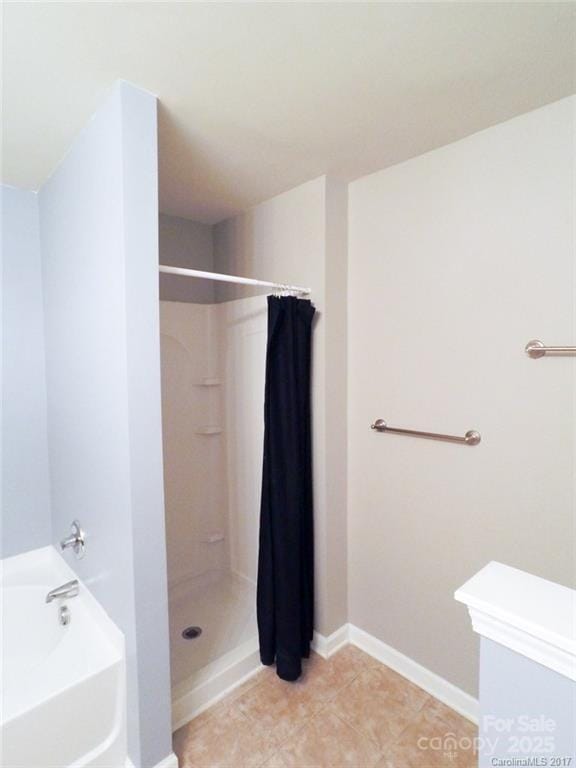 full bath with a bath, baseboards, tile patterned floors, and a stall shower