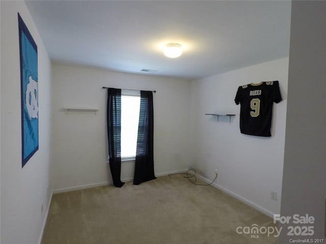 spare room featuring carpet floors and baseboards