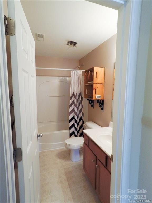 bathroom featuring shower / bath combo, toilet, and vanity