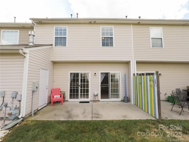 back of property featuring a lawn and a patio