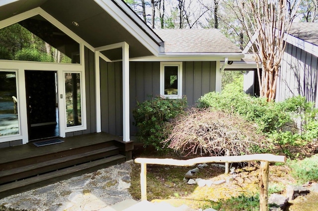 entrance to property with roof with shingles and board and batten siding