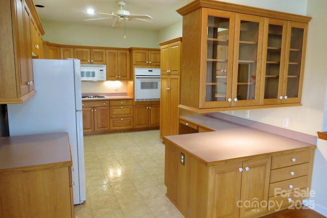 kitchen with glass insert cabinets, ceiling fan, white appliances, brown cabinets, and light floors