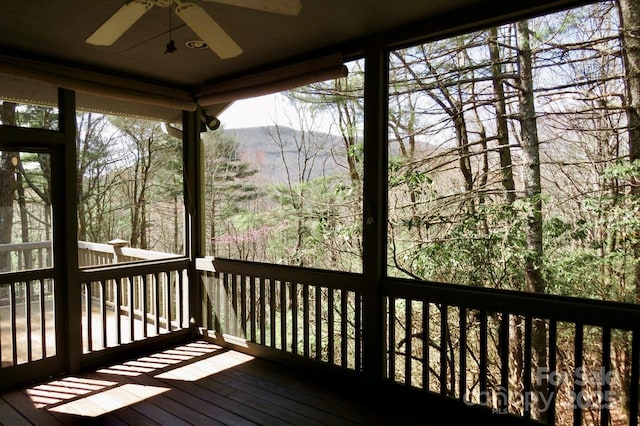 wooden terrace featuring a mountain view and ceiling fan