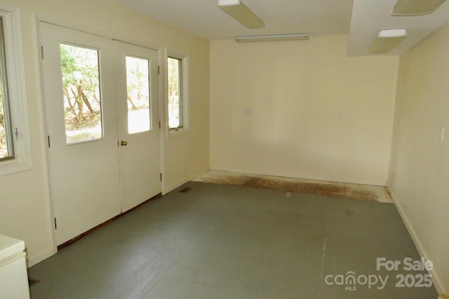 empty room featuring baseboards and plenty of natural light