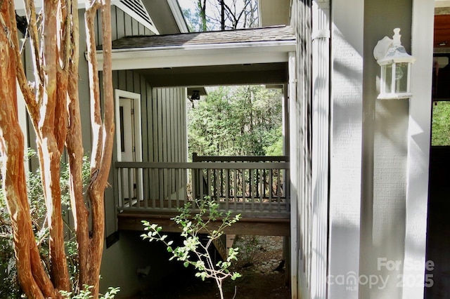 exterior space featuring board and batten siding and a shingled roof