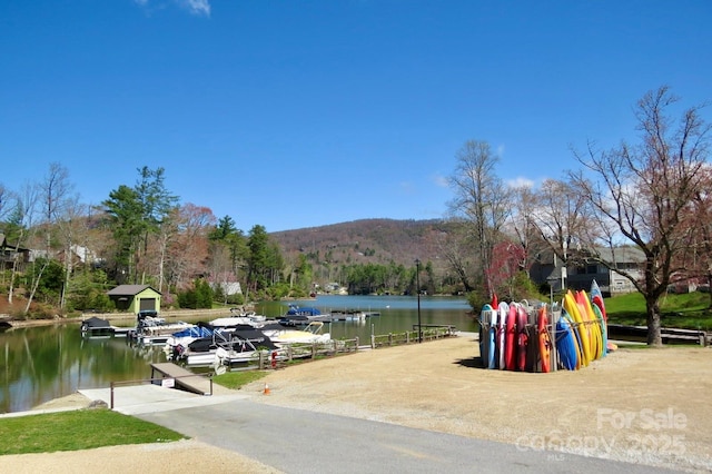exterior space with a water and mountain view and a boat dock