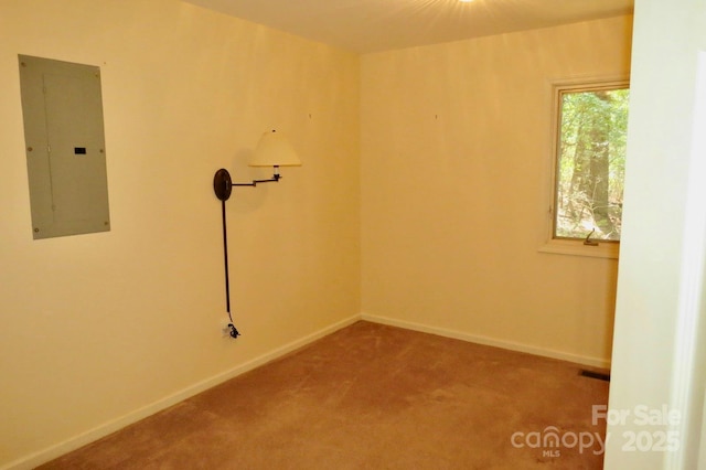 carpeted empty room with baseboards and electric panel