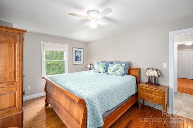 bedroom with a ceiling fan, baseboards, and wood finished floors