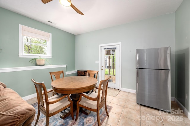 dining room featuring baseboards, ceiling fan, light tile patterned flooring, and visible vents