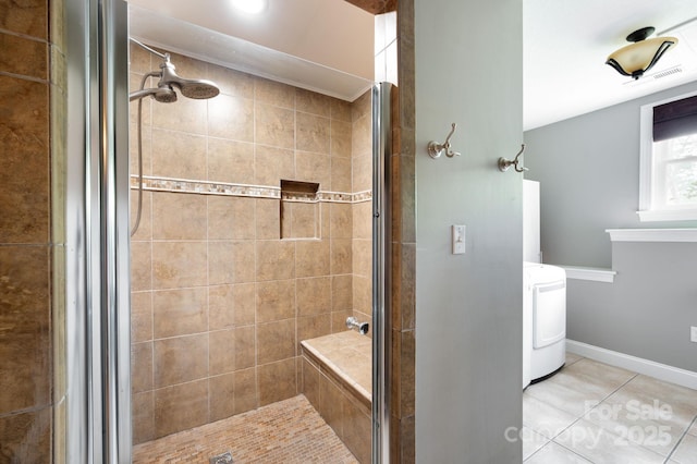 full bathroom featuring visible vents, a shower stall, tile patterned floors, baseboards, and washer / dryer